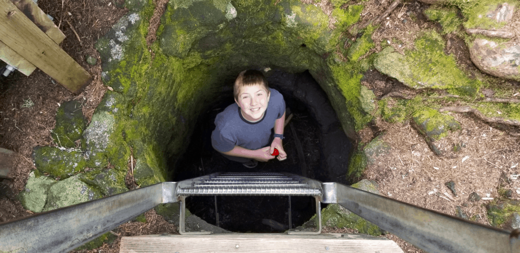 boy crawling in lava tube Washington