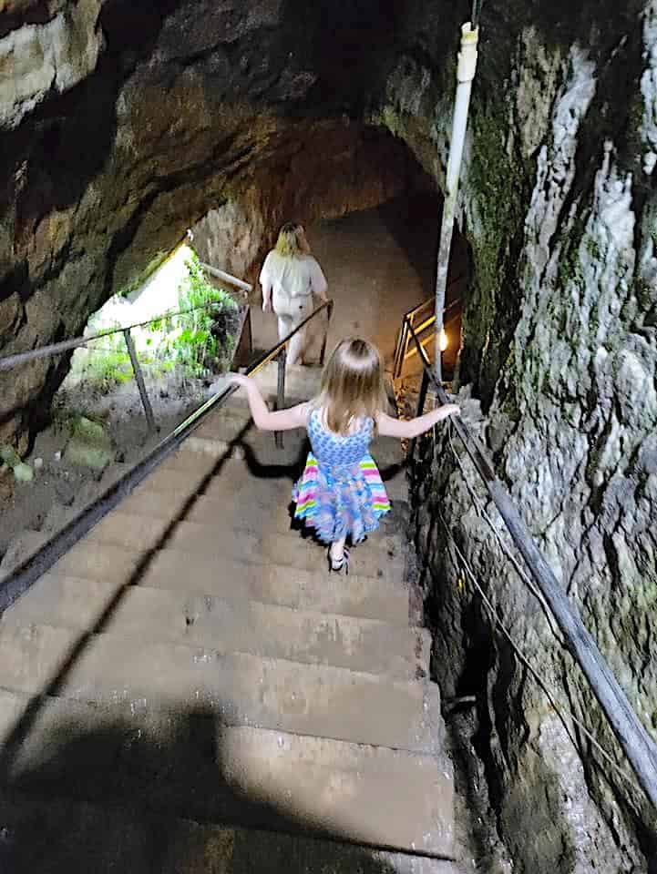 girl walking down cave stairs