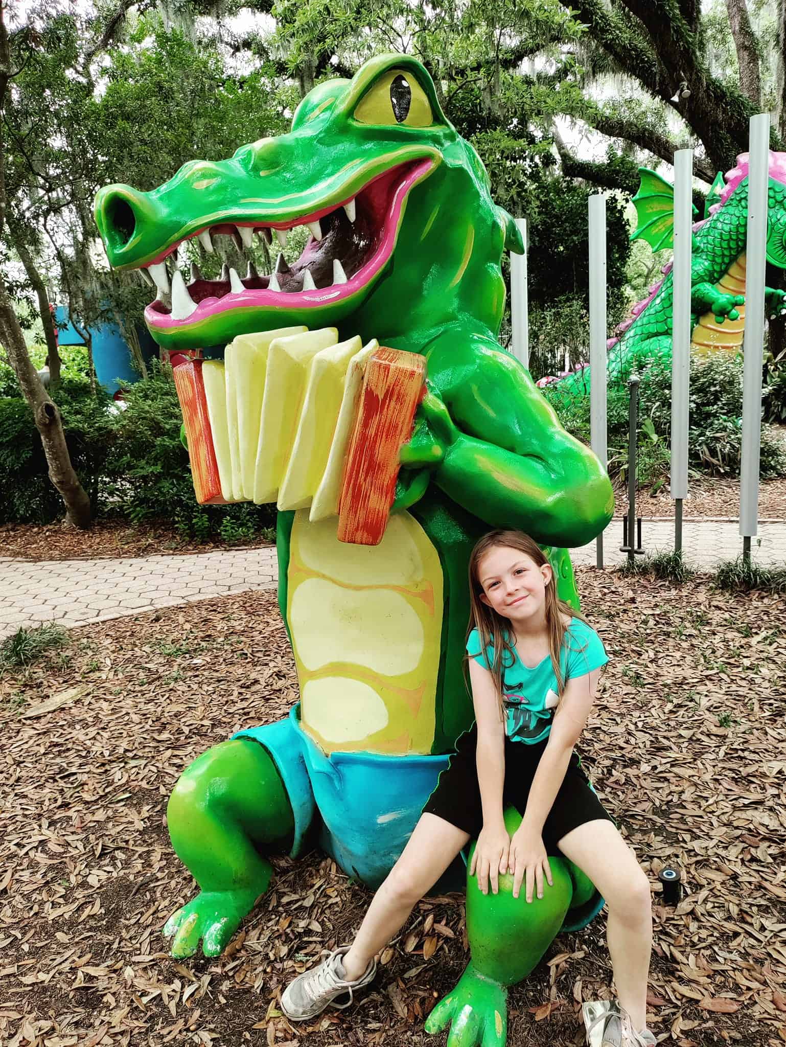 girl next to alligator statue in storyland city park